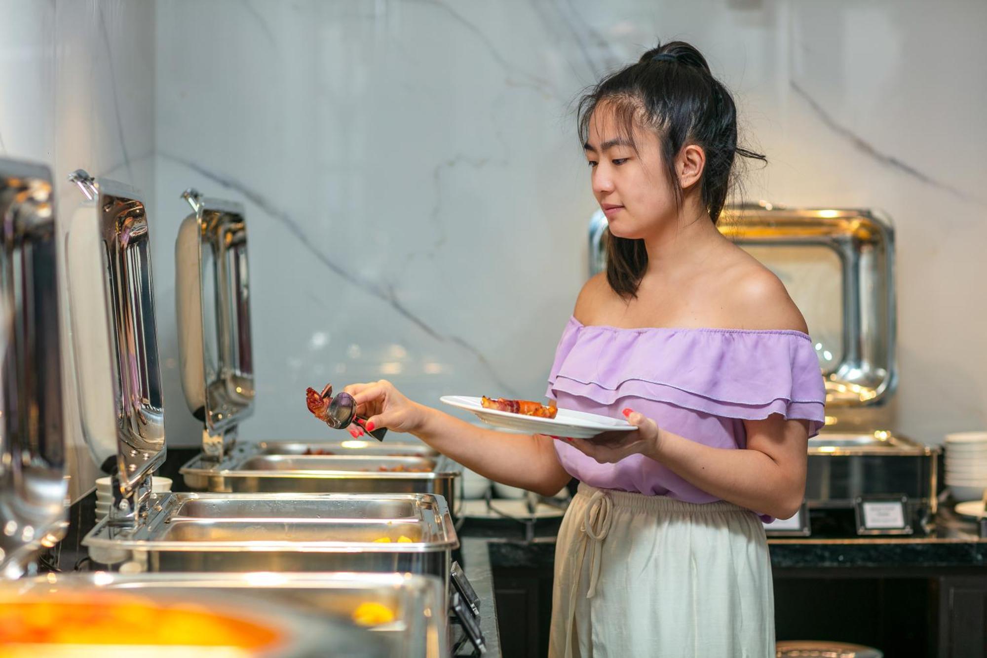 May De Ville Lakeside Hotel Ханой Екстер'єр фото A woman serving herself at a buffet